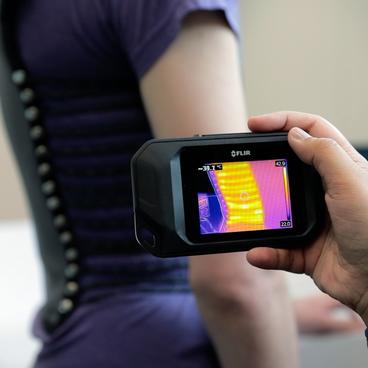 Photo of researcher observing compression vest with thermal camera